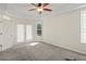 Spacious carpeted bedroom with tray ceilings, natural light, and a ceiling fan at 7216 Julian St, New Port Richey, FL 34653