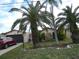 Charming single-story home with mature palm trees and a well-maintained front yard at 7308 Mako Dr, Hudson, FL 34667
