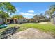 Large backyard with a storage shed, patio area, and lush greenery at 7353 Banner St, New Port Richey, FL 34653