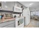 A view of the kitchen including an electric range, refrigerator, granite countertops, and breakfast area at 7353 Banner St, New Port Richey, FL 34653