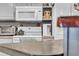 Bright kitchen with a white appliance suite, a toaster oven, and decorative items on the shelves at 7353 Banner St, New Port Richey, FL 34653
