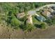 An aerial view showcases three homes with manicured lawns on a cul-de-sac surrounded by lush trees at 8910 Jericho Rd, Weeki Wachee, FL 34613