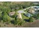 An aerial view showcases three homes with manicured lawns on a cul-de-sac surrounded by lush trees at 8910 Jericho Rd, Weeki Wachee, FL 34613