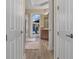 Hallway view to a bathroom, revealing modern fixtures, a shower, a tub, and outdoor access with a screened patio view at 8910 Jericho Rd, Weeki Wachee, FL 34613