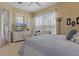 Comfortable bedroom featuring a large window, a desk, a TV, neutral colors, and an open doorway to an adjoining room at 8910 Jericho Rd, Weeki Wachee, FL 34613