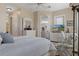 Inviting bedroom features neutral colors, a comfortable chair, TV, and an open doorway to an adjoining room at 8910 Jericho Rd, Weeki Wachee, FL 34613