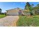 Attractive single-story home boasts a brick driveway, manicured lawn, and a welcoming, well-lit entrance at 8910 Jericho Rd, Weeki Wachee, FL 34613