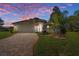 Charming home featuring a brick driveway, lush lawn, and well-maintained landscaping set against a beautiful sunset sky at 8910 Jericho Rd, Weeki Wachee, FL 34613