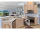 Well-lit kitchen with wooden cabinets, stainless steel appliances and an open drawer at 8910 Jericho Rd, Weeki Wachee, FL 34613