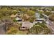 Aerial view showing the surrounding community, mature trees, pool and tennis courts at 1002 Caravel Ct, Tarpon Springs, FL 34689