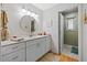 Bright bathroom features a double vanity with white cabinets, a circular mirror, and modern lighting at 1002 Caravel Ct, Tarpon Springs, FL 34689