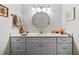 Stylish bathroom features a gray double vanity with elegant fixtures and a large circular mirror at 1002 Caravel Ct, Tarpon Springs, FL 34689