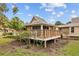 Outdoor deck perfect for relaxing with wooded railing, an exterior view, and manicured landscape at 1002 Caravel Ct, Tarpon Springs, FL 34689