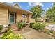 Inviting front entrance with flower pot decor and wood stairs leading to green door at 1002 Caravel Ct, Tarpon Springs, FL 34689
