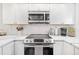 Modern kitchen featuring stainless steel appliances, white subway tile backsplash, and quartz countertops at 1002 Caravel Ct, Tarpon Springs, FL 34689