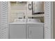 Convenient laundry area features a side-by-side washer and dryer, along with wire shelving for storage at 1002 Caravel Ct, Tarpon Springs, FL 34689