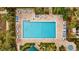 Aerial photo of a sparkling swimming pool with lounge chairs and tables in a private community setting at 1002 Caravel Ct, Tarpon Springs, FL 34689