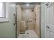 Updated shower featuring glass door, bronze fixtures, neutral tile, grab bar, and seat at 1002 Caravel Ct, Tarpon Springs, FL 34689