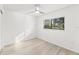 Bright bedroom featuring hardwood flooring, a ceiling fan, and a large window offering natural light at 1011 Altoona Ave, Spring Hill, FL 34609