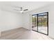 Bedroom with hardwood flooring, a ceiling fan, and sliding glass doors to the enclosed lanai at 1011 Altoona Ave, Spring Hill, FL 34609