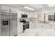 Updated kitchen features stainless steel appliances, white cabinetry, and granite countertops at 1011 Altoona Ave, Spring Hill, FL 34609