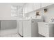 Bright laundry room features a utility sink, washer, dryer, folding counter, and ample cabinet space at 1011 Altoona Ave, Spring Hill, FL 34609