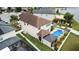 Aerial view of a two-story house and backyard with pool and privacy fence and mature landscaping at 11611 Lake Blvd, New Port Richey, FL 34655
