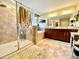 Bright bathroom features a glass enclosed shower, garden tub, dual sink vanity, and neutral tile flooring at 11611 Lake Blvd, New Port Richey, FL 34655