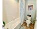 Bright bathroom featuring a bathtub with shower, white tile walls, and neutral accents at 11611 Lake Blvd, New Port Richey, FL 34655
