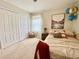 Bedroom features white closet doors, white walls, carpet, a white metal bed, and colorful decor at 11611 Lake Blvd, New Port Richey, FL 34655