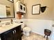 Charming half bathroom featuring white wainscoting, framed mirror, vanity with sink and tiled floors at 11611 Lake Blvd, New Port Richey, FL 34655