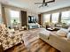 Spacious living room with wood-look floors, a ceiling fan, and lots of natural light at 11611 Lake Blvd, New Port Richey, FL 34655