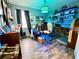 Bright home office featuring unique decor, custom shelving, gaming system and wood plank flooring at 11611 Lake Blvd, New Port Richey, FL 34655