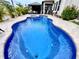 Sparkling swimming pool with a unique shape surrounded by lush greenery and a beautiful backyard setup at 11611 Lake Blvd, New Port Richey, FL 34655