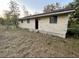 Exterior view of a house with light siding and neglected landscaping at 13140 Moon Rd, Brooksville, FL 34613