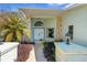 Inviting entrance to a light green house with natural stone accents, and a meticulously kept garden at 13819 Eagles Rock Ct, Hudson, FL 34667