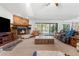 Warm living room featuring a stone fireplace, comfortable seating, and a pool view at 13819 Eagles Rock Ct, Hudson, FL 34667