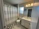 Bright bathroom featuring a shower with striped curtain, vanity with white cabinet, and stylish decor at 15384 Caravan Ave, Odessa, FL 33556