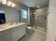 Bathroom with a double sink vanity and a glass-enclosed shower at 15384 Caravan Ave, Odessa, FL 33556