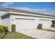 Three car garage with neutral paint, well manicured lawn, and simple landscaping at 15384 Caravan Ave, Odessa, FL 33556