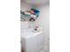 A laundry room with a white washer and dryer set, shelves, storage space and laundry supplies at 15384 Caravan Ave, Odessa, FL 33556