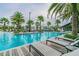 Community pool featuring lounge chairs, palm trees, and plenty of seating at 15384 Caravan Ave, Odessa, FL 33556
