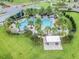 Aerial view of community pool featuring palm trees, a pavilion, and plenty of seating at 15384 Caravan Ave, Odessa, FL 33556