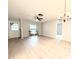 Well-lit living room with wood-look floors, an elegant light fixture, and a window overlooking the front yard at 1560 Autumn Rd, Spring Hill, FL 34608