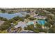 Overhead view of community amenities including pool, tennis courts, and lakefront property, surrounded by lush trees at 19325 Water Oak Dr # 205, Port Charlotte, FL 33948