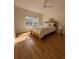 Bright bedroom with a queen bed, ceiling fan, wood floors and a large window offering natural light at 19325 Water Oak Dr # 205, Port Charlotte, FL 33948