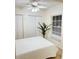 Bright bedroom features a ceiling fan, plantation blinds, and neutral walls at 19325 Water Oak Dr # 205, Port Charlotte, FL 33948