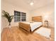 Bright bedroom with modern decor features wood-look floors, a queen bed, and a ceiling fan at 19325 Water Oak Dr # 205, Port Charlotte, FL 33948