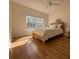 Bright bedroom with a queen bed, ceiling fan, wood floors and a large window offering natural light at 19325 Water Oak Dr # 205, Port Charlotte, FL 33948