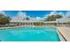Community pool with a clubhouse and plenty of chairs for lounging in the Florida sun at 19325 Water Oak Dr # 205, Port Charlotte, FL 33948